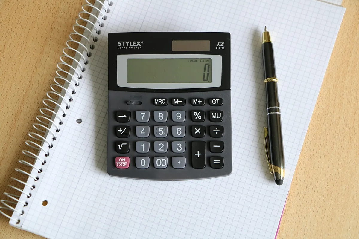 Calculator and pen on a notebook