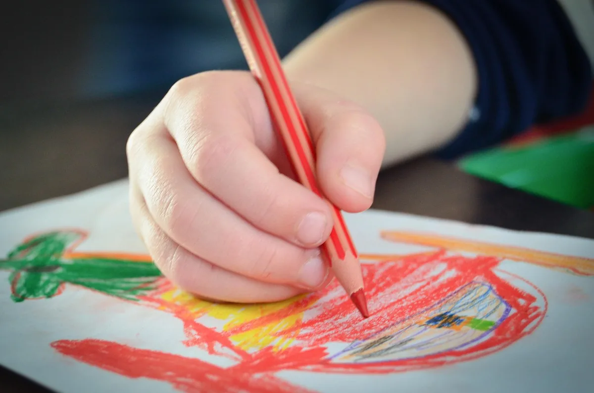 Child's hand drawing with a red crayon